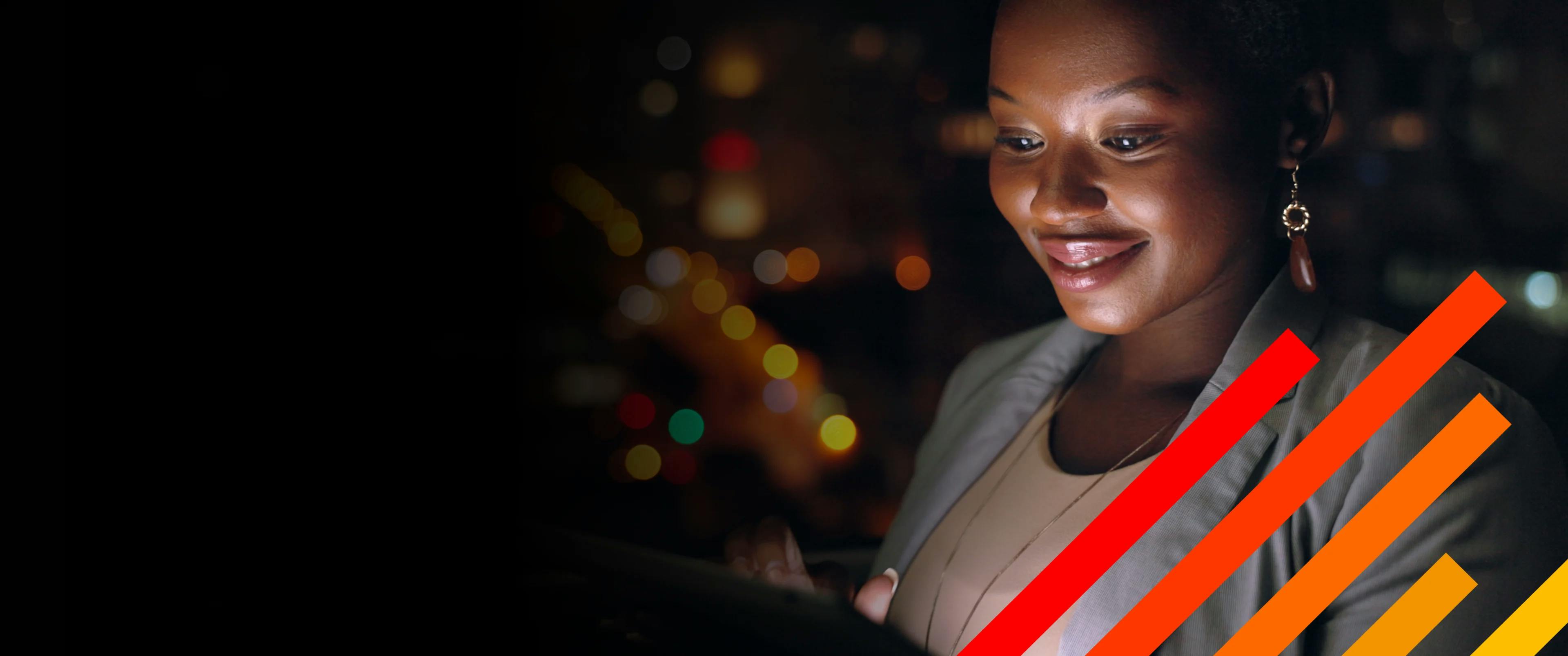 Nighttime image of business woman looking at screen with light reflecting on her face